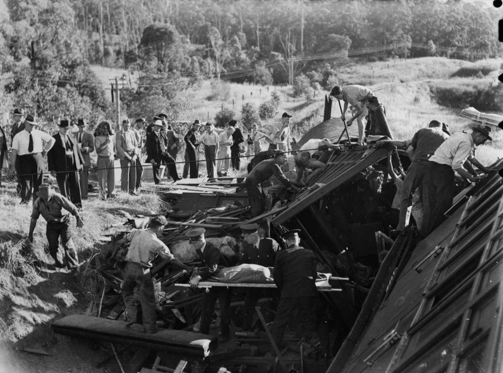 Rescue workers remove a body from a railway carriage at Camp Mountain, 1947