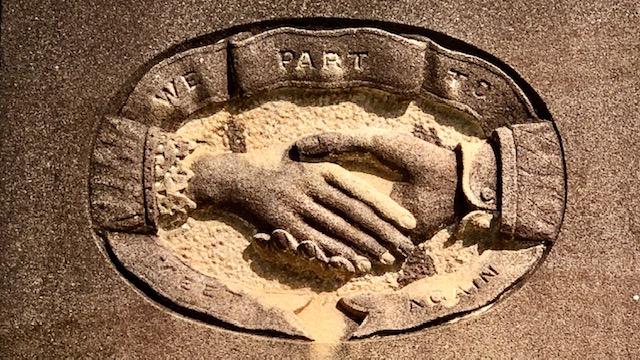 Headstone carving with man and women holding hands